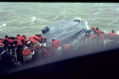 Passengers in lifejackets attempting to board a liferaft