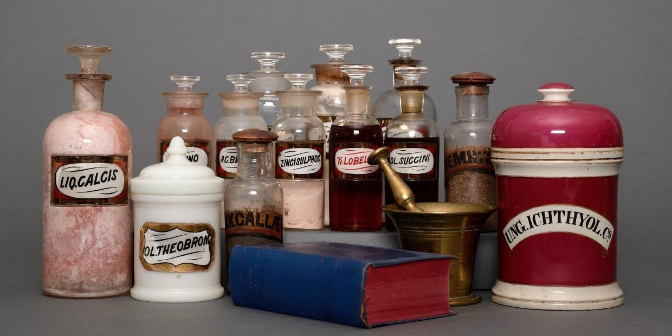 A group of vintage pharmaceutical bottles from the Castle Chemists collection on a grey background.
